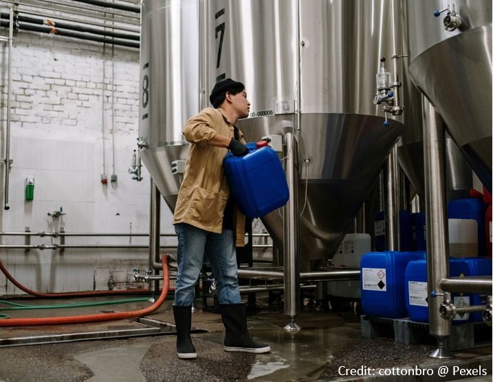 Image shows a plant operative loading chemical into a silo Credit-cottonbro, Pexels