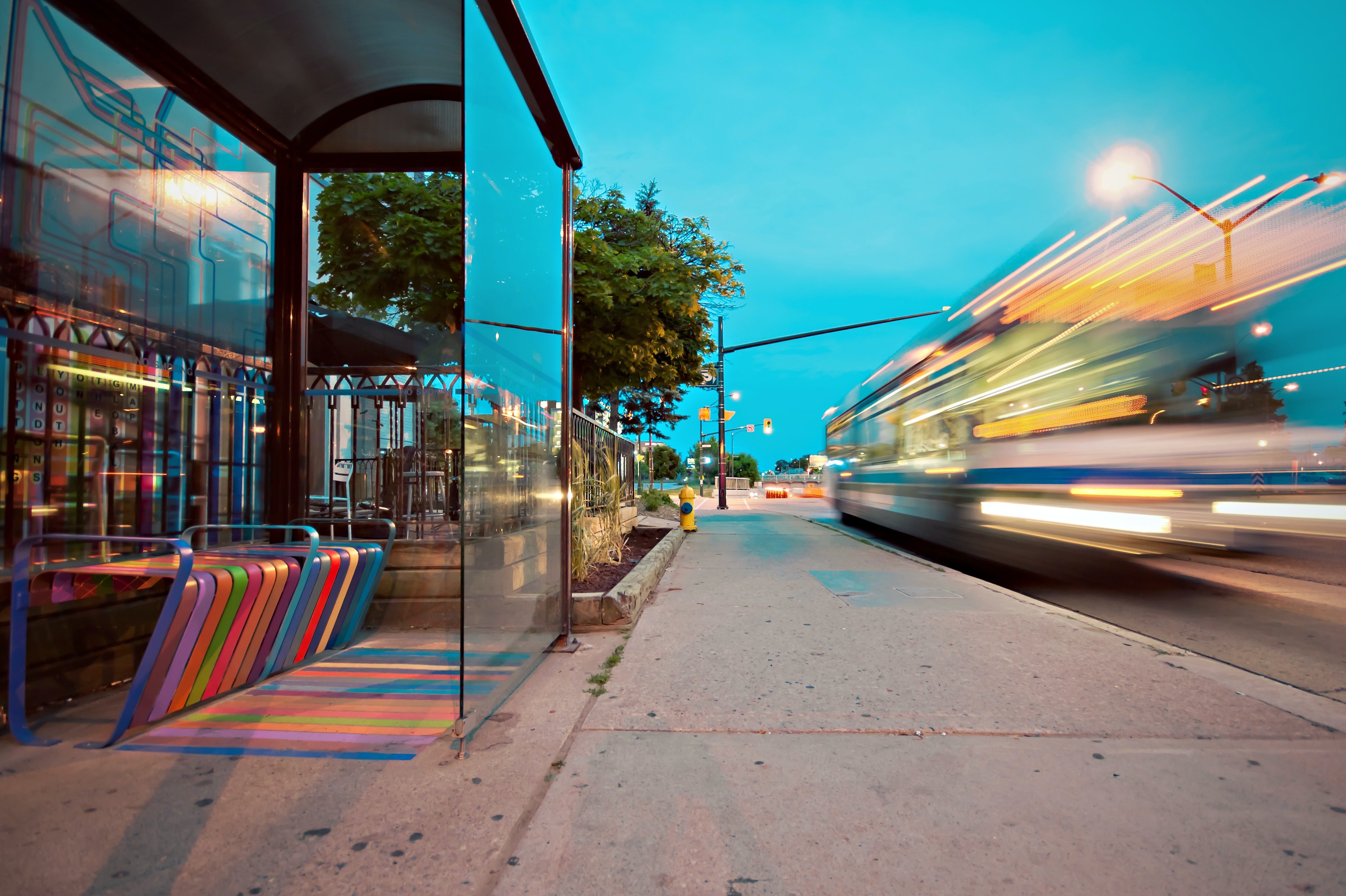 Image shows the blur of fast-moving vehicle passing a transport stop taken by Scott Webb and sourced from the online resource Pexels 